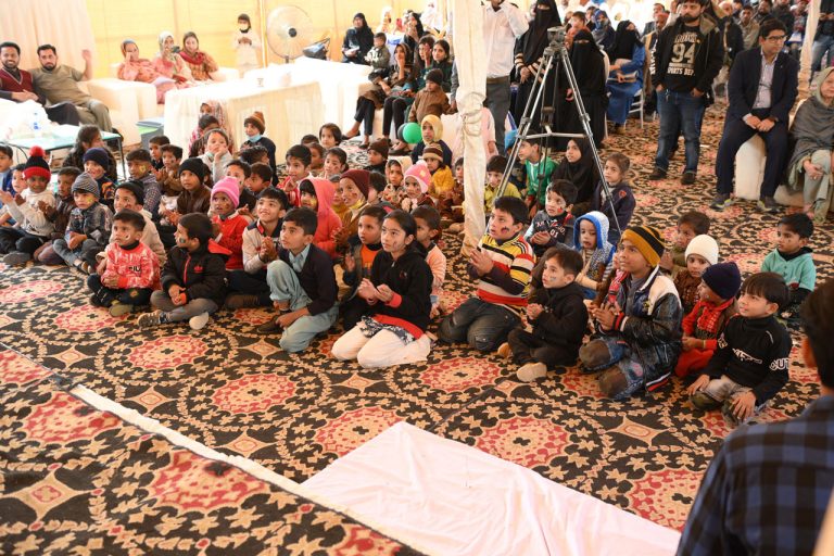 Pakistani children watching clown show at celebration