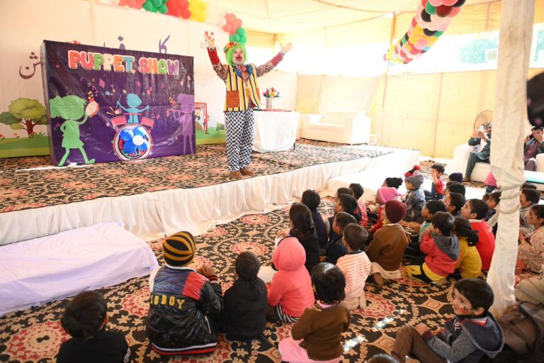 Pakistani children watching clown show at celebration